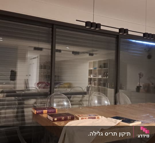 תריסים סגורים על חלון זכוכית גדול בחדר פנימי